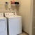 side-by-side washer/dryer in laundry room with built-in shelving and ample lighting